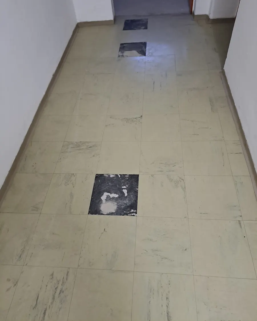 Flur mit Floor-Flex-Platten, an drei Stellen fehlen Platten und der schwarze Kleber darunter ist zu sehen