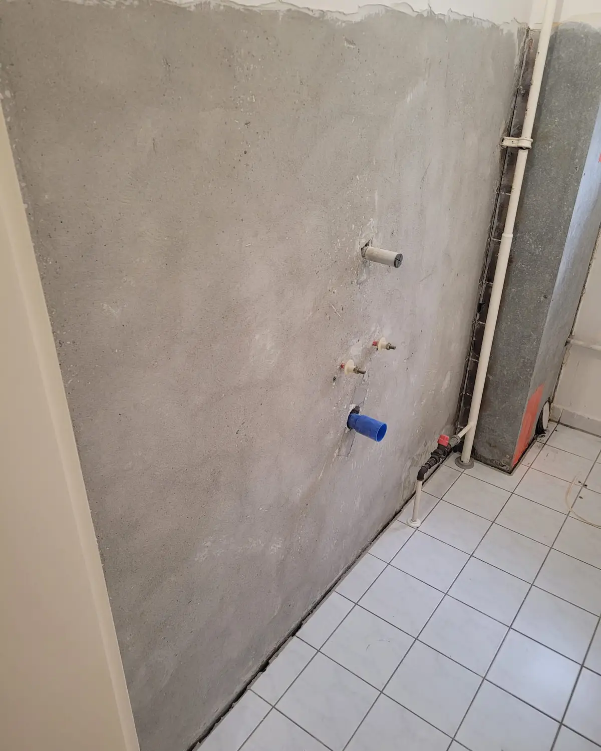 Wand nach der Asbestsanierung: Die Fliesen sind entfernt und der asbesthaltige Fliesenkleber ist abgefräst